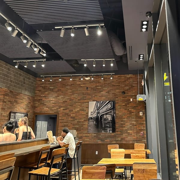 Interior of Stubbys restaurant with brick walls, track lighting, and customers dining at a bar and tables.